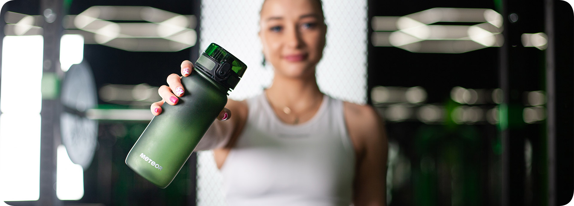 Dziewczyna w stroju fitness trzymająca bidon