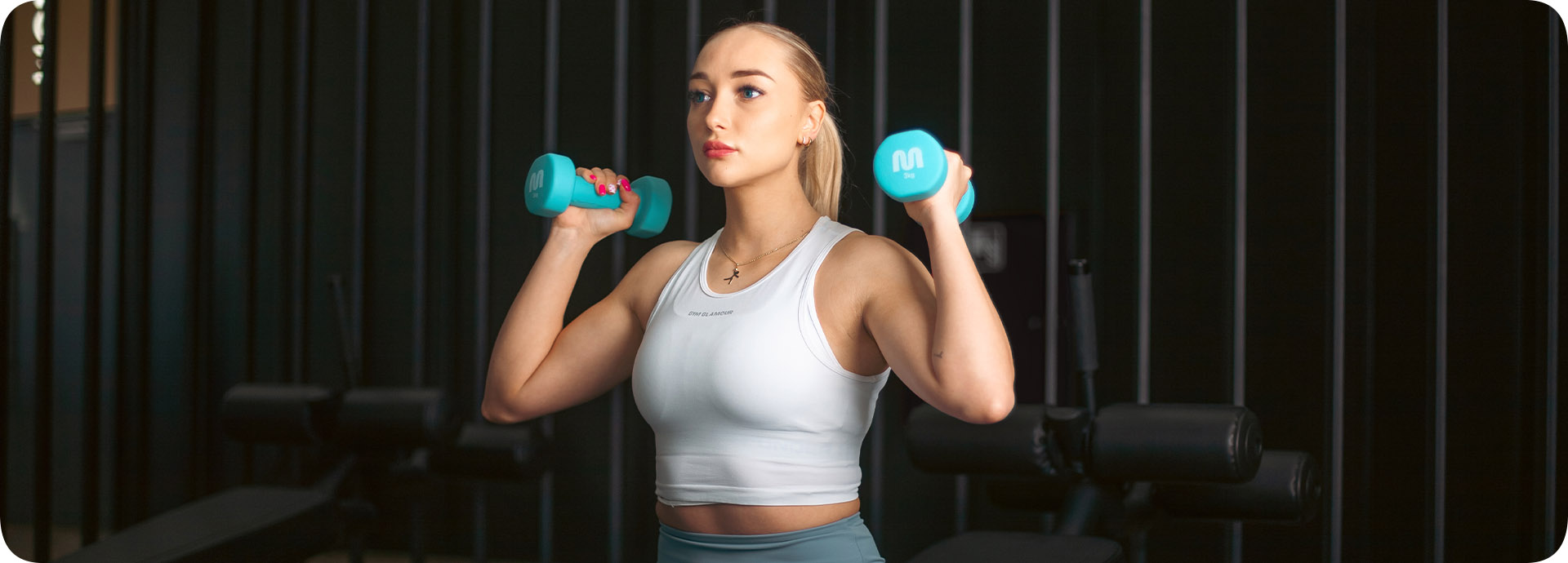 Młoda dziewczyna w stroju fitness z hantlami